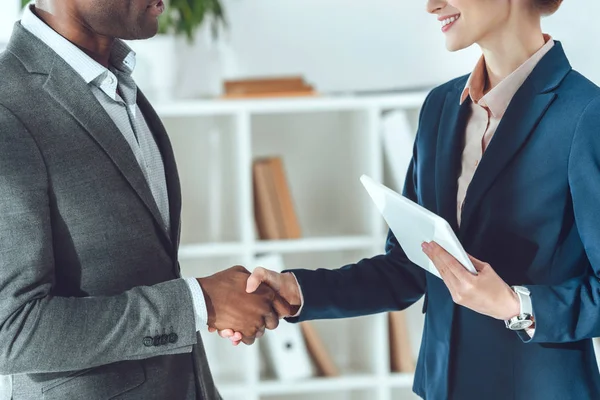 Cropped image of african american businessman and businesswoman shaking hands — Stock Photo