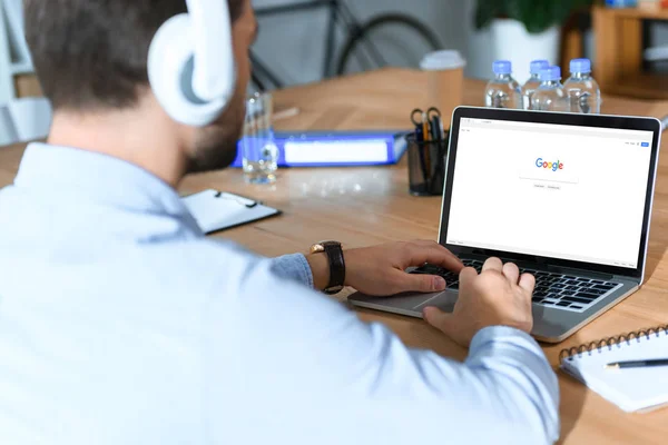 Homem de negócios usando laptop com página do google carregado — Fotografia de Stock