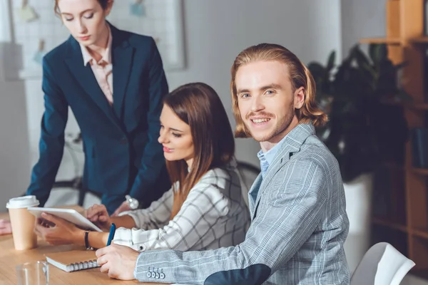 Schöner Geschäftsmann schaut während eines Treffens in die Kamera — Stockfoto