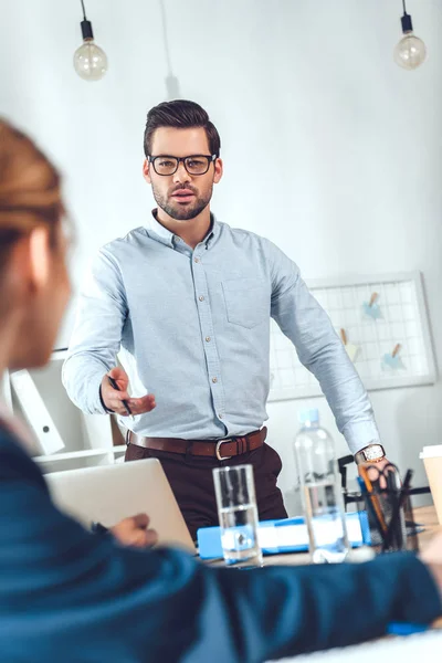 Cropped image of businesswoman and businessman talking in office — Stock Photo