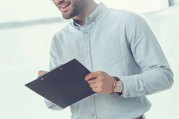 Abgeschnittenes Bild eines kaukasischen Mannes mit einem Ordner im Büro — Stockfoto