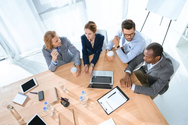 Geschäftsteam sitzt am Tisch und diskutiert in Büroräumen — Stockfoto