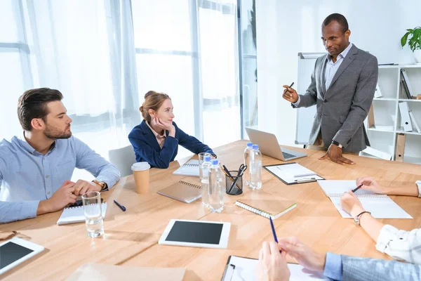 Hombre africano de pie contra portátil en la mesa en el espacio de oficina — Stock Photo