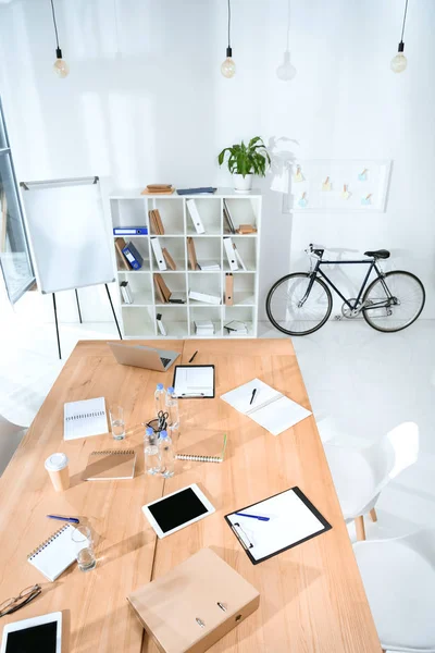 Вид на порожній офісний інтер'єр зі столом і велосипедом на стіну — стокове фото