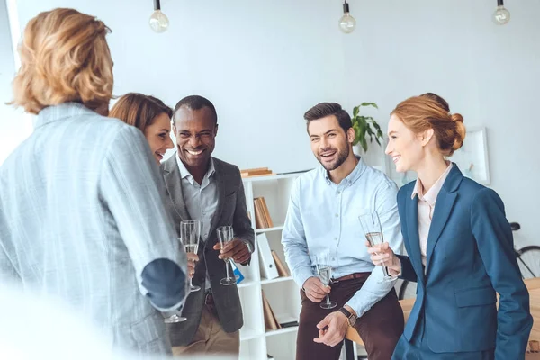 Equipo de negocios que celebra con bebidas en vasos en el espacio de oficina - foto de stock