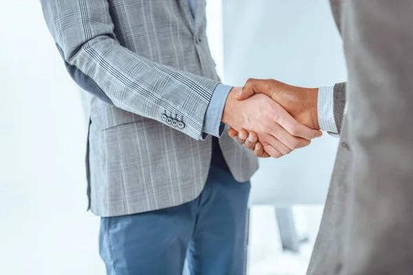 Imagem cortada de dois empresários apertando as mãos no espaço do escritório — Fotografia de Stock