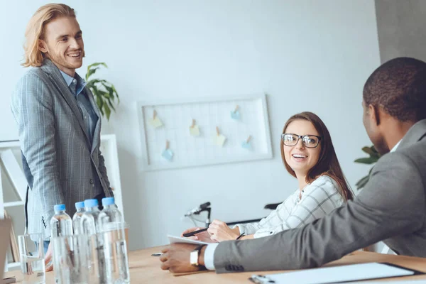 Business team sitting at table and speaking at office space — Stock Photo