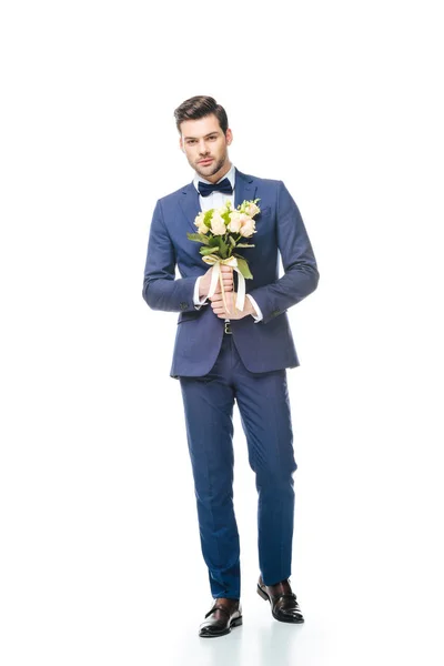 Fashionable groom with wedding bouquet in hands isolated on white — Stock Photo