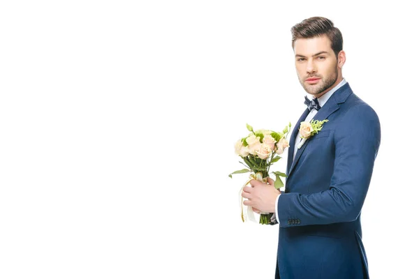 Portrait of stylish groom in suit with wedding bouquet isolated on white — Stock Photo