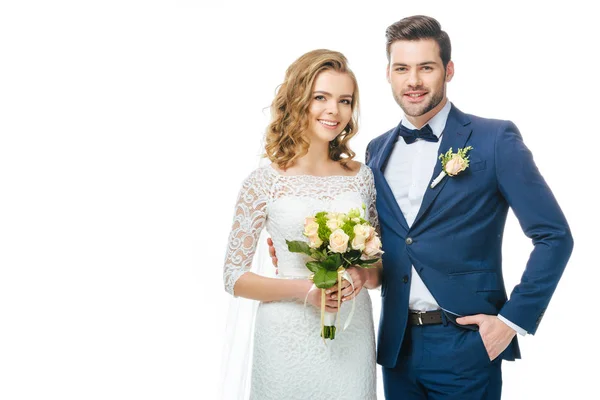 Портрет улыбающейся невесты со свадебным букетом и женихом, изолированным на белом — стоковое фото