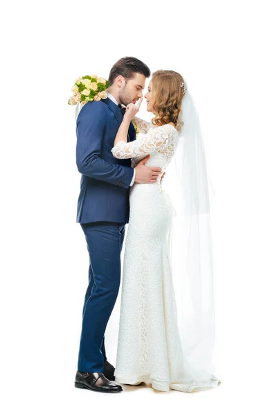 Seitenansicht eines jungen Hochzeitspaares, das sich isoliert auf Weiß betrachtet — Stockfoto