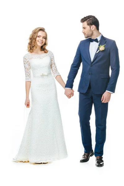 Bello sposo e sposa tenendo le mani isolate su bianco — Foto stock