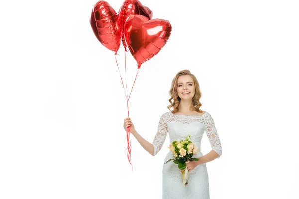 Hermosa novia en vestido de novia con globos en forma de corazón y ramo de boda aislado en blanco - foto de stock