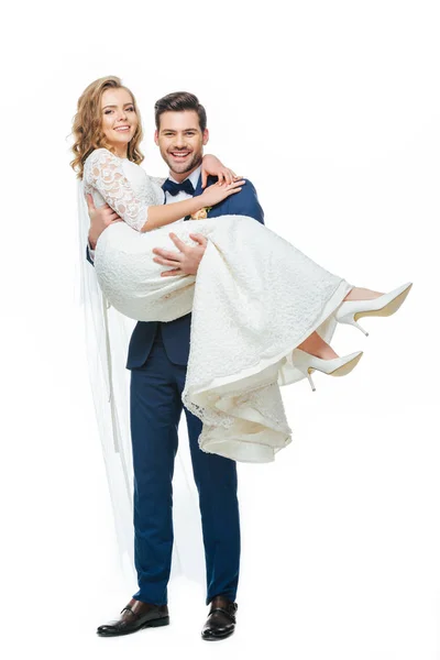 Giovane sposo tenendo bella sposa su mani isolate su bianco — Foto stock