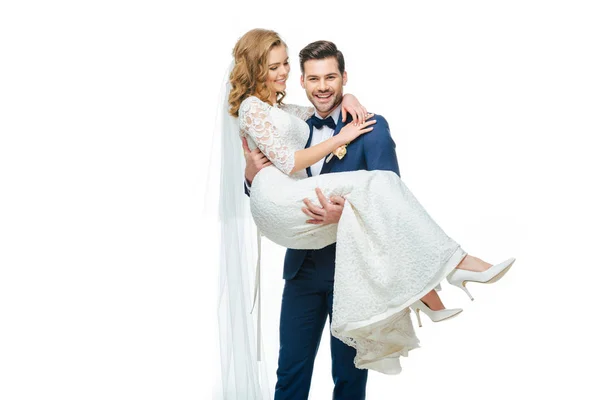 Young groom holding beautiful bride on hands isolated on white — Stock Photo