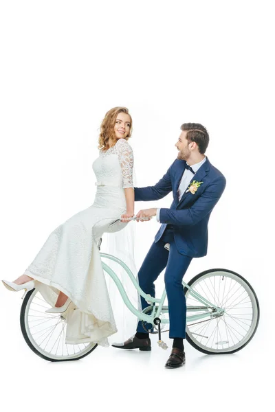 Wedding couple riding retro bicycle isolated on white — Stock Photo