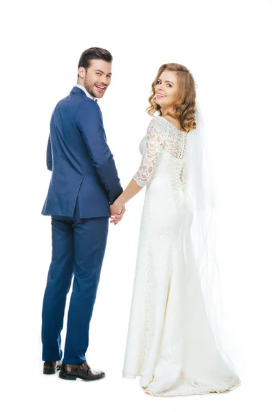 Back view of beautiful wedding couple holding hands isolated on white — Stock Photo