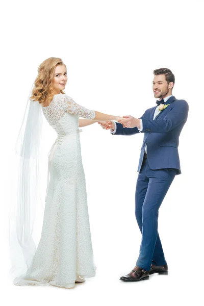 Schönes Hochzeitspaar Händchen haltend beim gemeinsamen Tanzen isoliert auf Weiß — Stockfoto