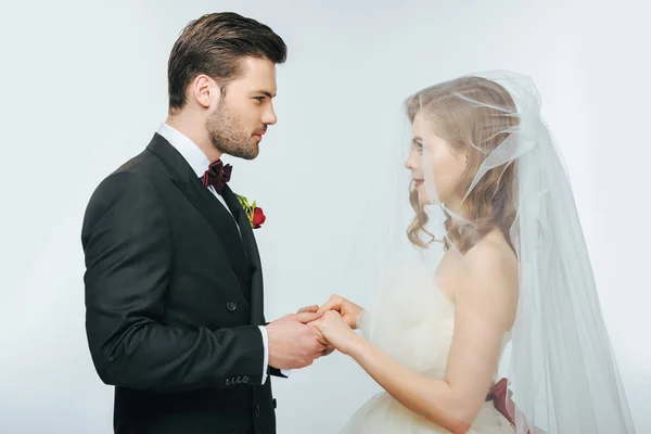 Side view of beautiful wedding couple holding hands and looking at each other — Stock Photo