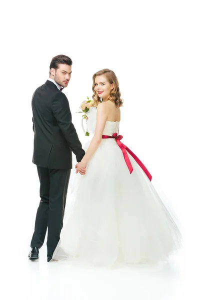 Вид ззаду весільної пари, що тримає руки ізольовані на білому — стокове фото