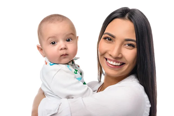 Retrato de madre alegre con bebé en las manos aisladas en blanco - foto de stock
