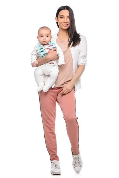 Mulher sorridente com bebê adorável na mão olhando para a câmera isolada no branco — Fotografia de Stock