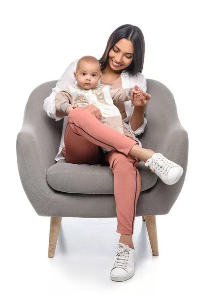 Sorridente giovane madre appoggiata sulla poltrona insieme al piccolo bambino isolato sul bianco — Foto stock