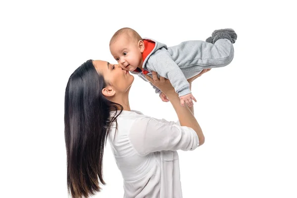 Вид збоку матері цілує милий немовля ізольовано на білому — стокове фото
