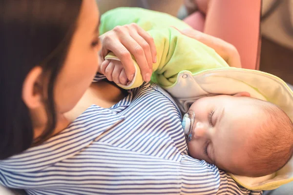 Enfoque selectivo del bebé bebé durmiendo en las manos de las madres - foto de stock