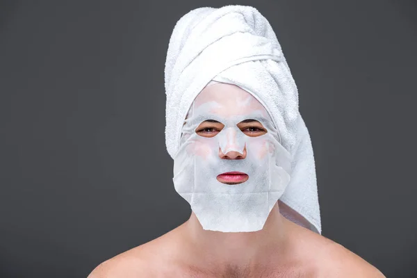 Bel homme avec serviette et masque de collagène, isolé sur gris, concept de soins de la peau — Photo de stock