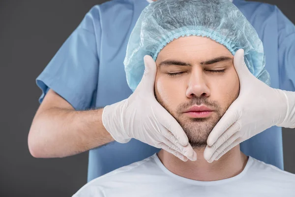 Hombre guapo barbudo con los ojos cerrados listo para el lifting facial, aislado en gris - foto de stock