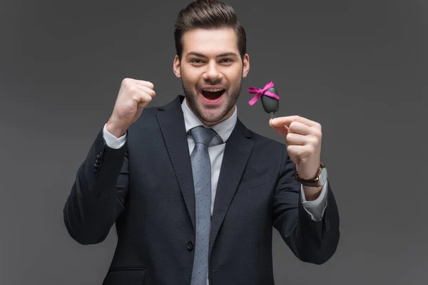 Excited businessman holding car key, isolated on grey — Stock Photo