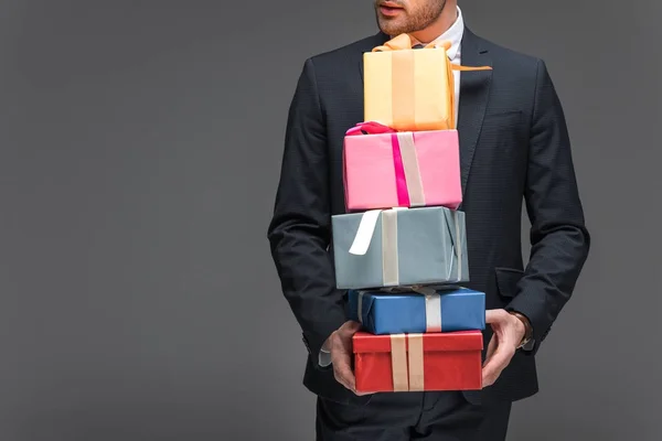 Vista recortada del hombre sosteniendo cajas de regalo, aislado en gris - foto de stock