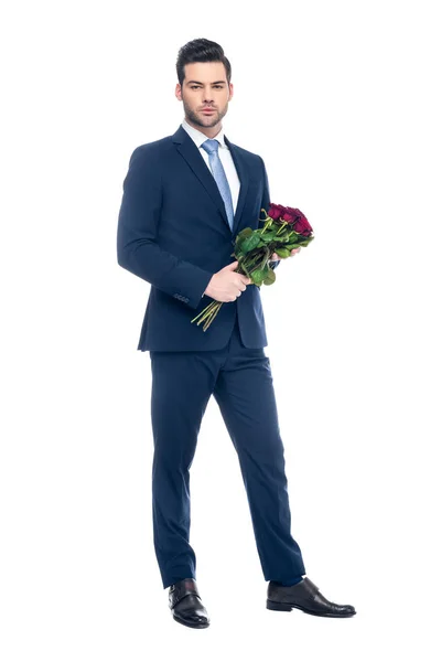 Bell'uomo elegante che tiene bouquet di rose rosse, isolato su bianco — Foto stock
