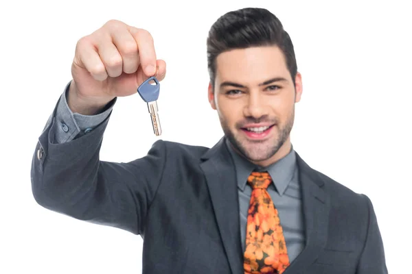 Cheerful realtor holding house key, isolated on white — Stock Photo