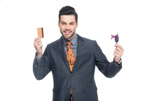 Guapo hombre de negocios con tarjeta de crédito y llave del coche, aislado en blanco - foto de stock