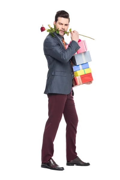 Hombre barbudo sosteniendo regalos y rosa roja, aislado en blanco - foto de stock