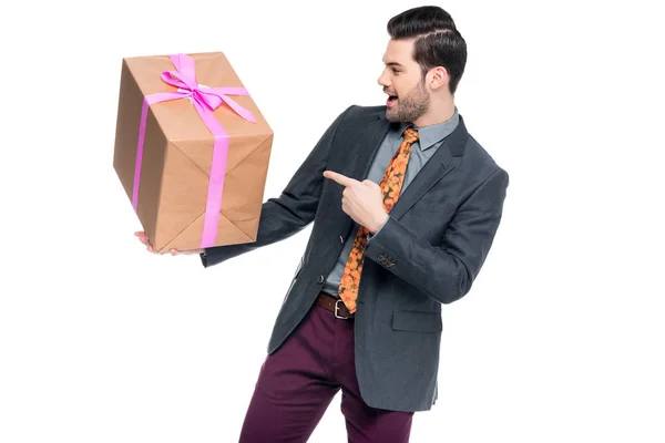 Handsome excited man pointing at gift box, isolated on white — Stock Photo