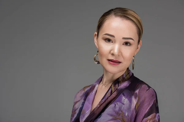 Retrato de elegante mujer kazakh elegante mirando a la cámara aislada en gris - foto de stock