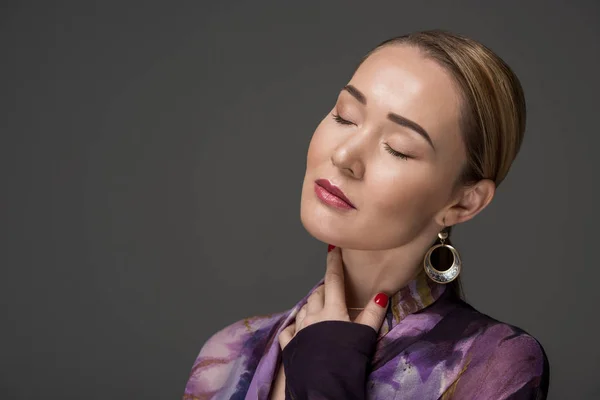 Porträt einer sinnlichen kasachischen Frau mit geschlossenen Augen, die isoliert auf grau posiert — Stockfoto