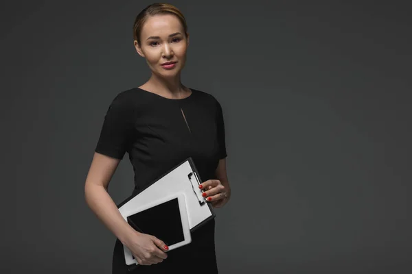 Красива казахська бізнес-леді з цифровим планшетом і буфера, посміхаючись на камеру ізольована на сірому — стокове фото