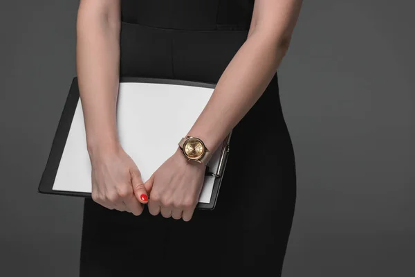 Крупним планом частковий вид бізнес-леді тримає буфер обміну ізольовано на сірому — стокове фото
