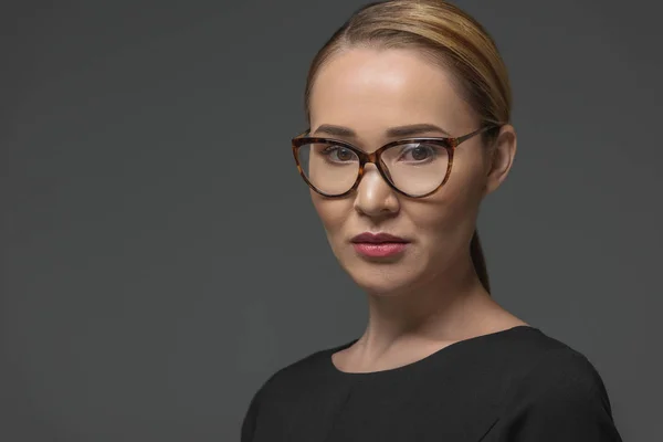 Primer plano retrato de hermosa mujer kazakh en gafas mirando cámara aislada en gris - foto de stock