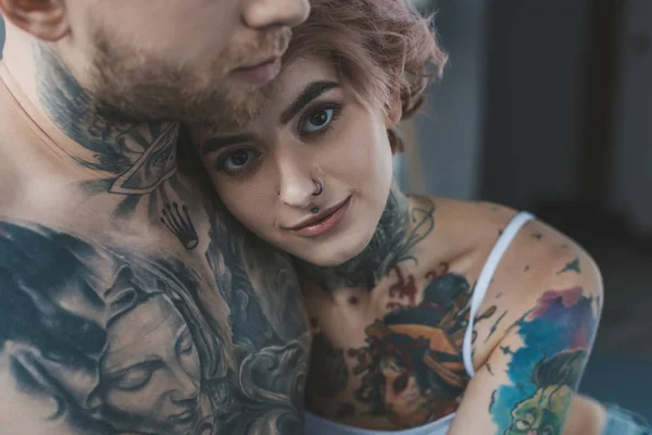 Jovem tatuado menina abraçando seu namorado — Fotografia de Stock