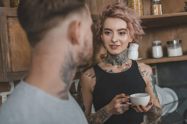 Hermosa pareja tatuada beber café juntos por la mañana - foto de stock