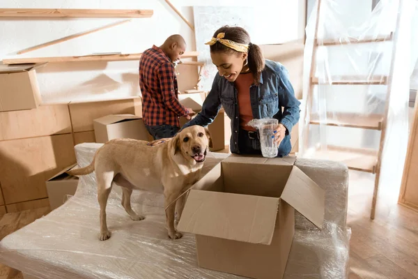 Casal afro-americano com cão labrador se mudando para nova casa — Fotografia de Stock