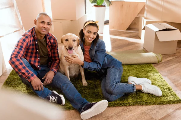 Africano americano pareja con labrador perro mudanza a nuevo apartamento — Stock Photo