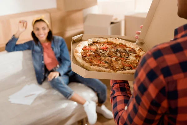 Recortado vista de novio trayendo pizza para su novia - foto de stock