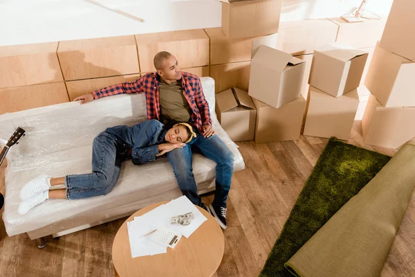 Афро-американських пара, відпочиваючи в нову квартиру з коробки з мікрогофрокартону — стокове фото
