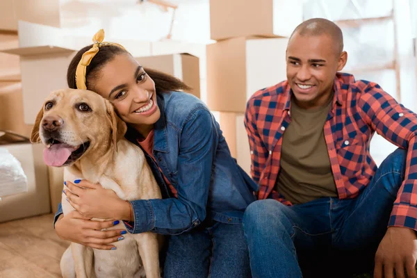 Felice famiglia afro-americana con cane labrador trasferirsi in un nuovo appartamento — Foto stock